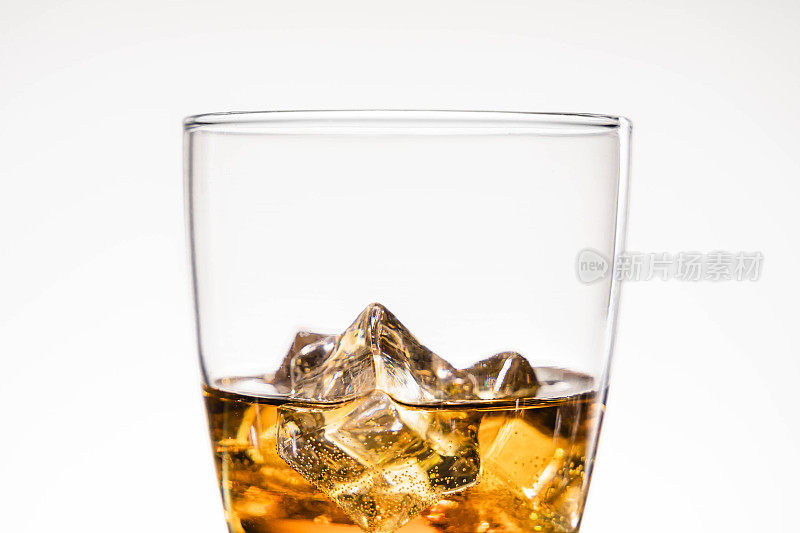 Glass of whiskey with ice cubes on white background